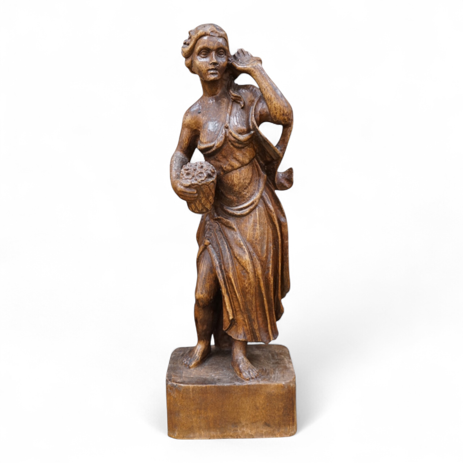 A carved walnut figure of a girl holding a basket of flowers, 54cm high